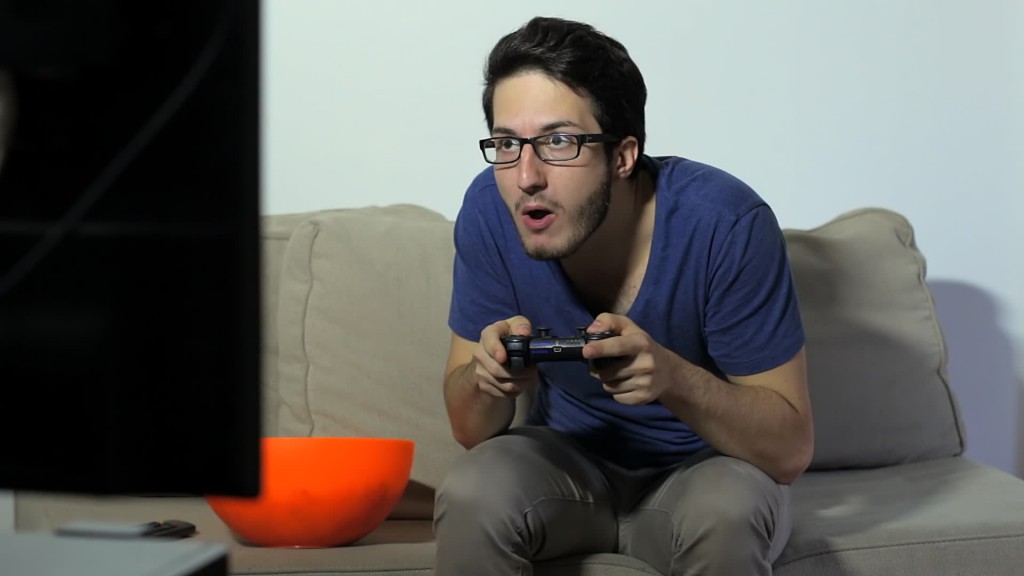 stock footage a fun loving video gamer playing with a wireless joystick while eating popcorn