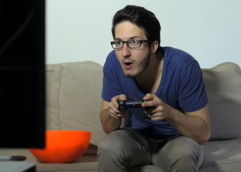 stock footage a fun loving video gamer playing with a wireless joystick while eating popcorn