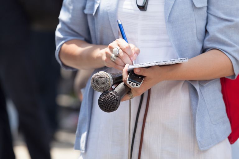 midsection of journalist holding microphones while writing on note pad 878027776 5ae3885e04d1cf003cf1fce5