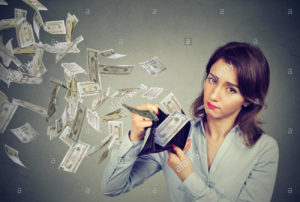 sad woman showing her wallet with money dollar banknotes flying out K1GNG7 e1580661555264